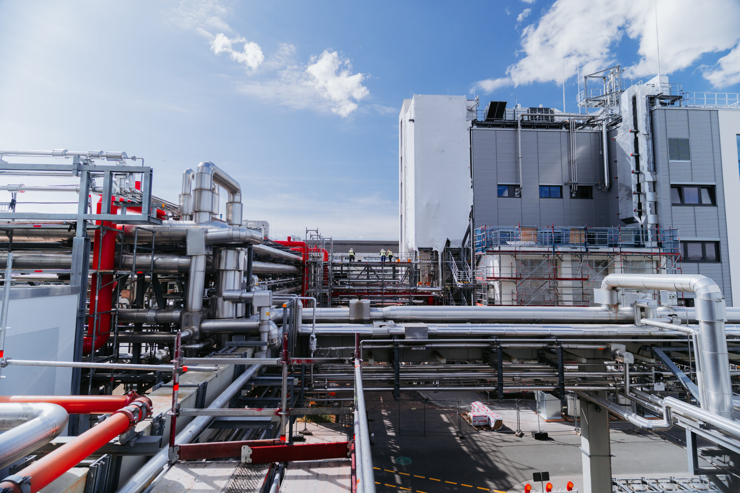 Zu sehen ist eine Industrieanlage mit Gerüst, Rohren und Stahlträgern.